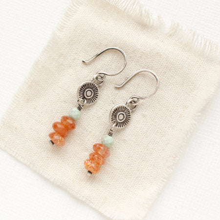 The stacked mesa talara sun earrings styled on tan linen