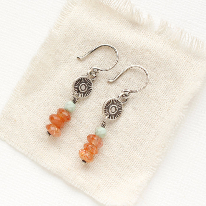 The stacked mesa talara sun earrings styled on tan linen