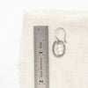 A stacked pearl mini hoop earring next to a ruler for size reference