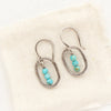 The stacked turquoise mini hoop earrings styled on tan linen