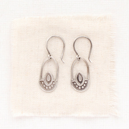 The wanderer hoop earrings styled on tan linen