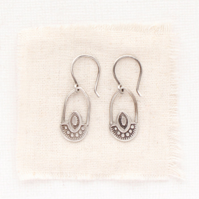 The wanderer hoop earrings styled on tan linen
