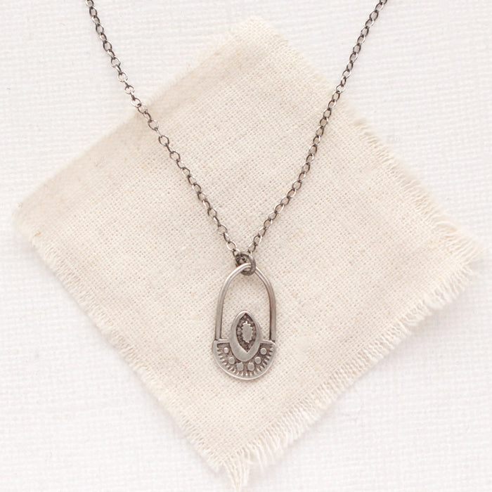 The wanderer hoop necklace styled on tan linen