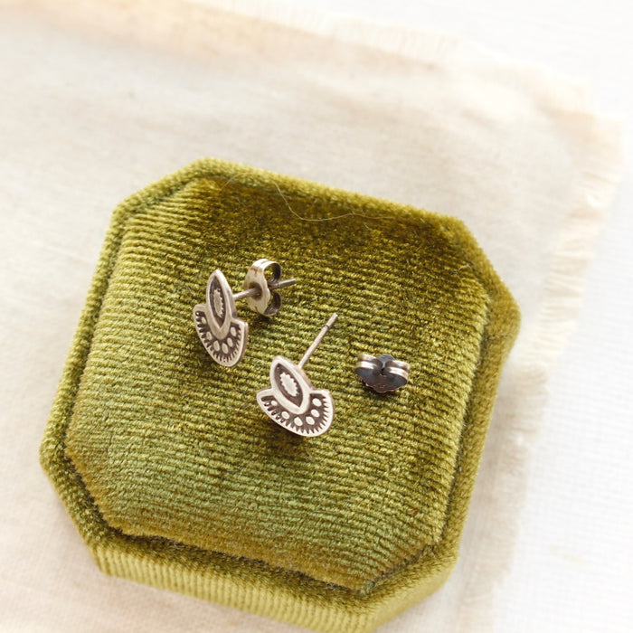 The wanderer post earrings styled on a green velvet box to show the butterfly earbacks