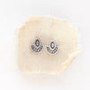 The wanderer post earrings styled on tan linen