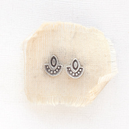 The wanderer post earrings styled on tan linen