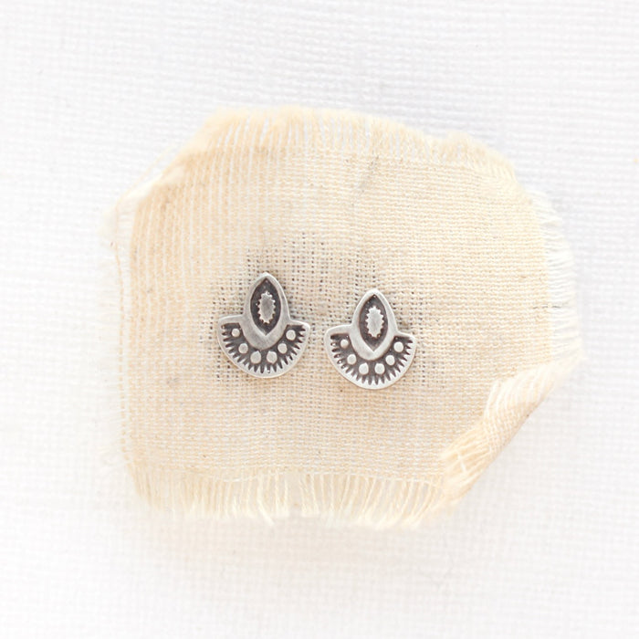 The wanderer post earrings styled on tan linen