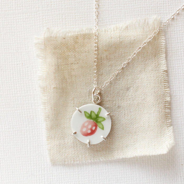 The strawberry bud vintage plate necklace styled on tan linen