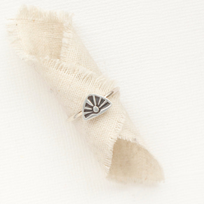 The sun rise stacking ring styled on a piece of rolled linen