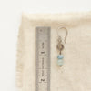 A talara sun aquamarine earring next to a ruler for size reference