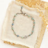 The talara sun kyanite bracelet styled on tan linen with a tan rock and dried grass