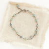 The silver wrapped kyanite talara sun bracelet styled on tan linen