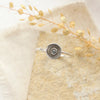 The talara sun ring styled on a tan rock with linen and dried grass
