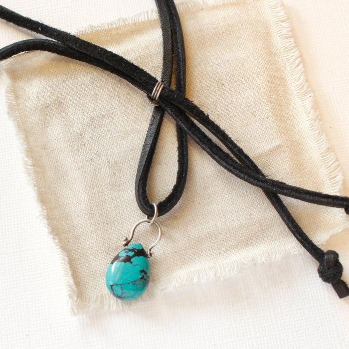 The turquoise drop adjustable leather necklace styled on tan linen
