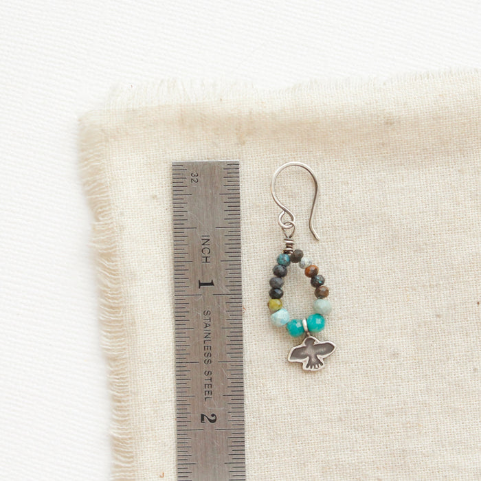 A serenity soar hoop earring next to a ruler for size reference