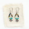 The serenity soar hoop earrings styled on tan linen