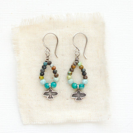 The serenity soar hoop earrings styled on tan linen