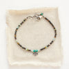 The serenity soar bracelet styled on tan linen