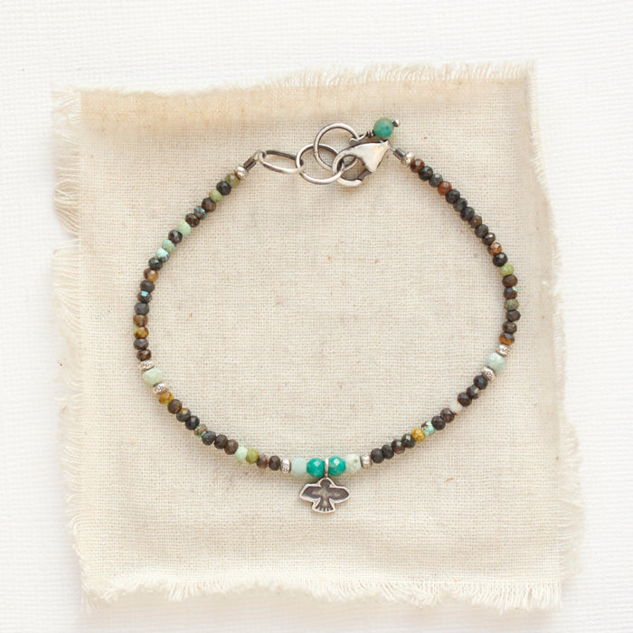The serenity soar bracelet styled on tan linen