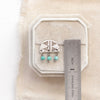 A turquoise pakal arch post earring next to a ruler for size reference