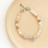 The mini cactus flower violet jade bracelet styled on a tan plate
