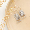 The wanderer arch mixed metal labradorite earrings styled on a tan plate with dried grass