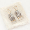 The wanderer arch mixed metal labradorite earrings styled on tan linen