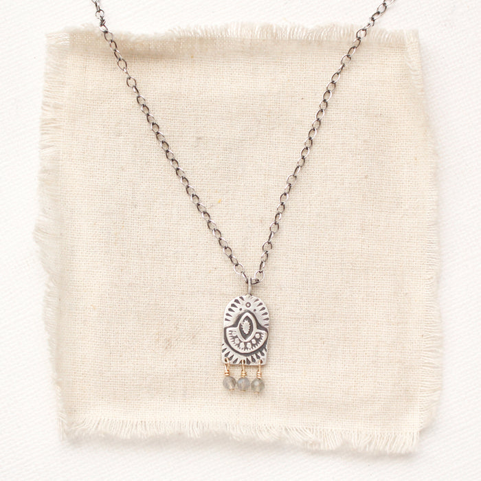 The wanderer arch mixed metal labradorite necklace styled on tan linen