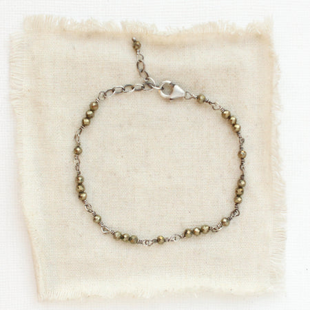 The wrapped pyrite bracelet styled on tan linen