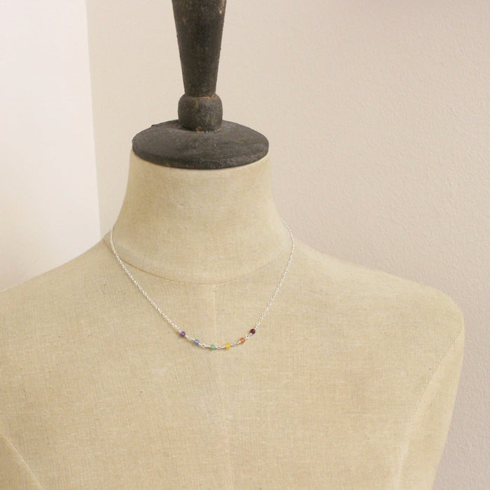 A mannequin wearing the wrapped silver rainbow necklace