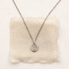 The zuni cross necklace styled on tan linen