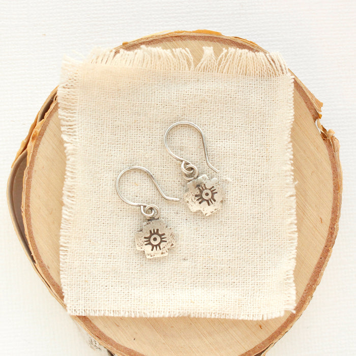 The zuni cross earrings styled on wood and tan linen