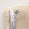 An aspen leaf post earring next to a ruler for size reference