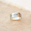 The woodgrain texture band ring styled on tan linen