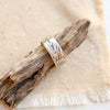 The woodgrain texture band ring styled on a stick on tan linen