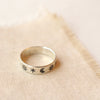 The celestial stamped ring styled on tan linen