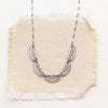 The asmi 5 collar necklace styled on tan linen