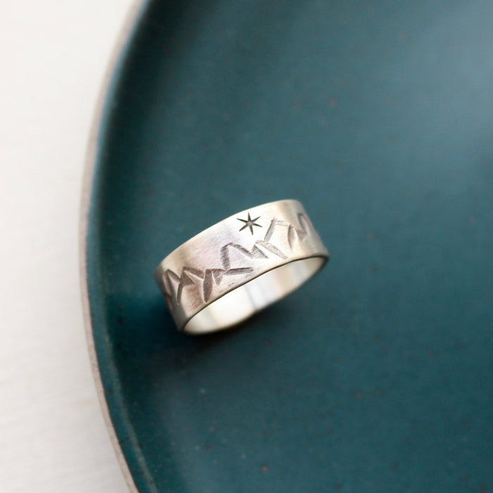 The stamped mountain range ring styled on a blue plate