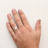 The stamped mountain range ring styled on a hand to show size reference