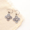 The stamped silver layered talara earrings styled on tan linen