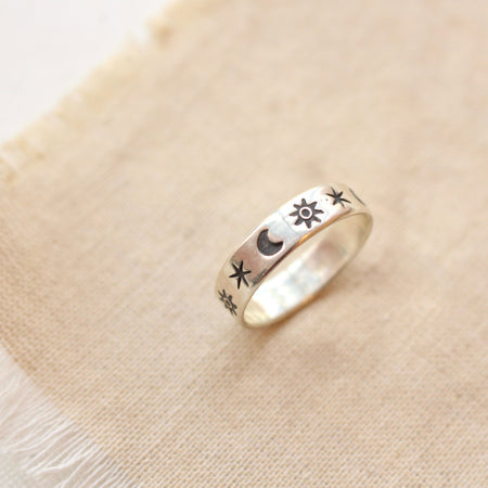 The celestial stamped silver ring styled on tan linen