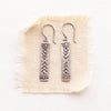 sun bar earrings on tan linen