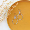 The talara sun hoop earrings styled on a yellow plate with dried grass