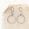 The silver talara sun hoop earrings styled on tan linen