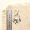 A layered talara earring next to a ruler for size reference