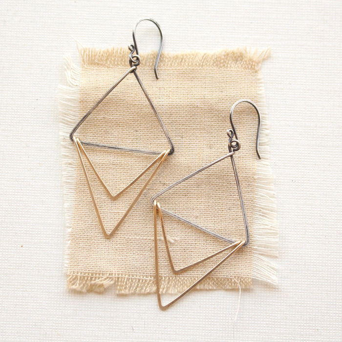The mixed metal triple triangle hoop earrings styled on tan linen