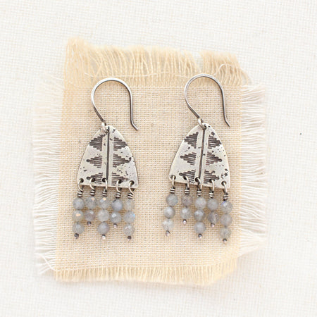 The pakal arch labradorite fringe earrings styled on tan linen