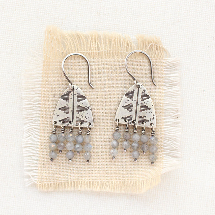 The pakal arch labradorite fringe earrings styled on tan linen