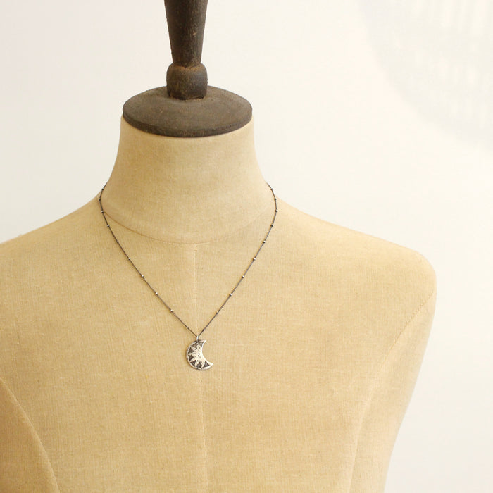 A mannequin wearing the pakal moon necklace