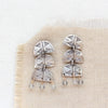 The pakal trio labradorite dangle post earrings styled on tan linen